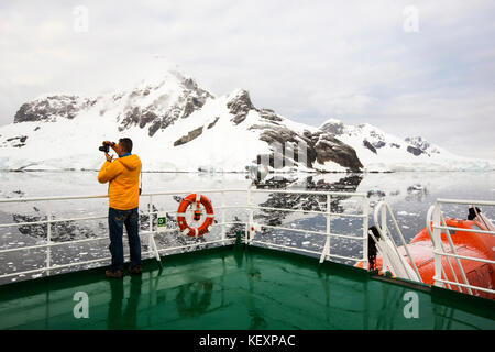 Ein Passagier auf dem Deck der Akademik Sergey Vavilov, einem eisverstärkten Schiff auf einer Expedition in die Antarktis, vor der Antarktischen Halbinsel. Stockfoto