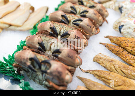 Reihen von frischen Krabben auf Eis mit Preisen hand auf ihre Krallen für den Verkauf auf einen Fisch Hetzer Markt in Yorkshire, England stall geschrieben Stockfoto