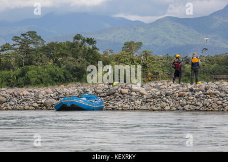 Foto mit Ansicht der Rückseite zwei Männer beobachten Drohne fliegen beim Stoppen von Rafting Jungle River in den Manu Nationalpark, Peru Stockfoto