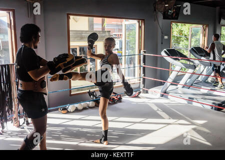 Foto der jungen Frau treten beim Üben Kickboxen mit Trainer, Seminyak, Bali, Indonesien Stockfoto