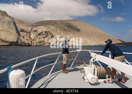 Foto von zwei männlichen Seeleuten am Bug des Schiffes, das auf der Insel San Benedicto, Revillagigedo Islands, Colima, Mexiko ankommt Stockfoto