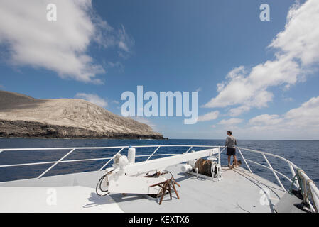 Foto von einem einzigen Mann, der vom Schiff aus die San Benedicto Insel betrachtet, Revillagigedo Inseln, Colima, Mexiko Stockfoto