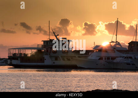 Boote im Hafen von Paphos mit der untergehenden Sonne am Mittelmeer Horizont, Paphos, Zypern, Europa. Stockfoto