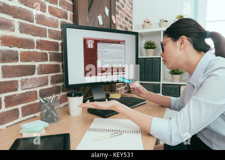 Unglücklich Office Manager Gefühl, wenn Sie mit Kreditkarte bezahlen online Lösegeld aber Ihr Computer noch immer Virus erpressen verwirrt. Stockfoto