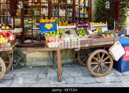 Bunte Obst barrow Anzeige Außen- und Gemüsehändler shop, Broadway, Worcestershire, einem wunderschönen Dorf in den Cotswolds, Süd-West-England, Großbritannien Stockfoto