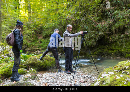 Professionelle Fotografen mit Kameras auf einem Stativ schießen in einem Fluss Stockfoto