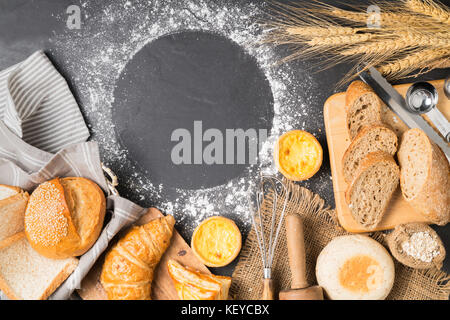 Mix Brot, Croissant, Baguette, Muffin und Ei tart auf schwarzem Stein, Ansicht von oben kopieren und Platz für in Text Stockfoto