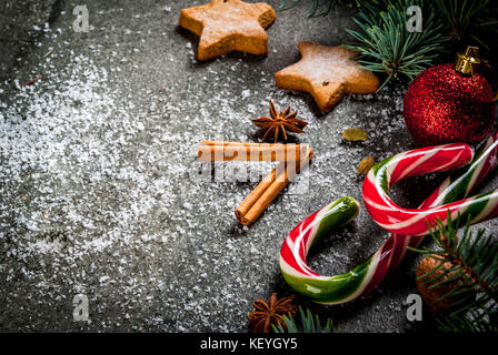 Weihnachten dunklen Hintergrund mit Weihnachtsbaum Äste, Tannenzapfen, Zuckerstange Süßigkeiten, Geschenke, Weihnachtskugeln und Dekorationen, Kopie Raum Stockfoto