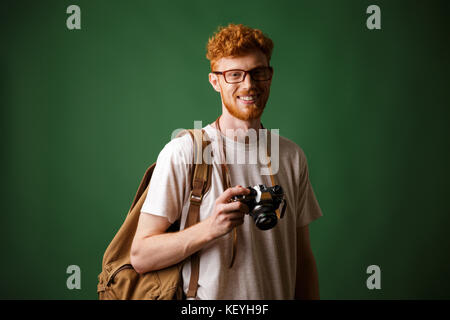 Der Abtastkopf bärtigen Hipster mit retro Kamera und Rucksack, auf grünem Hintergrund Stockfoto