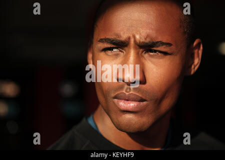 Close up Portrait von einem gutaussehenden jungen afrikanischen Mann weg suchen Stockfoto