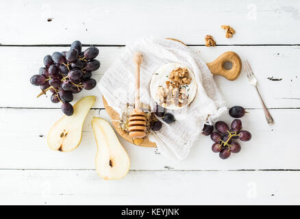Camembert Käse mit Trauben, Nüssen, Birnen und Honig auf vintage Metallplatte Stockfoto