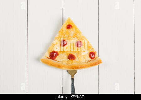 Stück Pizza auf eine Gabel auf einem hölzernen Hintergrund Stockfoto