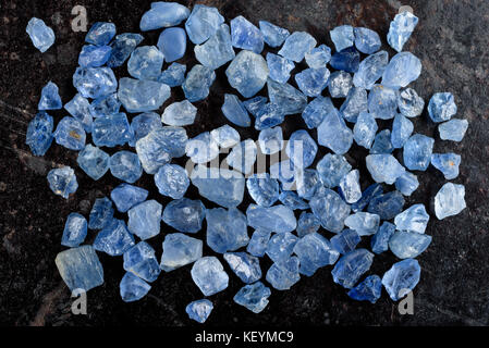 Sammlung von schönen blauen rau und ungeschliffen Saphir Edelsteine auf schwarzen Stein Schiefer. Stockfoto