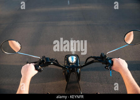Zugeschnittenes Bild der Mensch, er reitet auf modernen Motorrad auf der Straße draußen Stockfoto