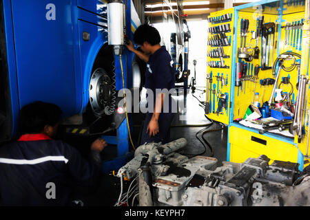 Blur Kfz-mechaniker Kontrolle Tourist Bus vor der Reise Transport im Bus Garage. Selektive konzentrieren. Stockfoto