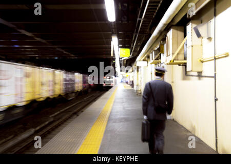 Blur nicht identifizierter Zugfahrer läuft zum JR Train am Bahnhof in Japan. Stockfoto