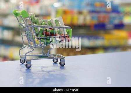 Medizin in einem mini Trolley auf einen Zähler mit Apotheke Hintergrund. Stockfoto