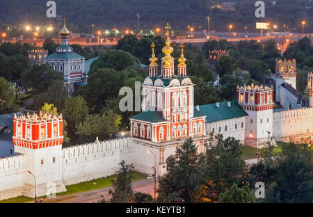 Russisch-orthodoxe Torhaus Kirche und ein Teil der Mauer mit Türmen des Neujungfrauenklosters am Abend. Moskau, Russland Stockfoto