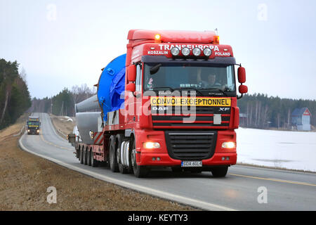 Salo, Finnland - 11. März 2016: rot DAF XF105 Semi Truck gewerbeobjekt als außergewöhnliche Belastung im Konvoi Hols mit einem ähnlichen Transport. Ely ce Stockfoto