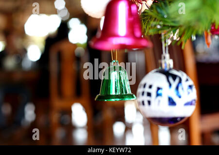 Grüne Glocke und verschiedene Ornamente auf Weihnachten Weihnachtsbaum dekoriert Stockfoto