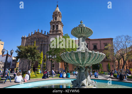 Januar 18, 2016 San Luis Potosi, Mexiko: Leute sitzen auf Rim von Wasser Brunnen vor der Kathedrale von San Luis in der kolonialen Altstadt Stockfoto