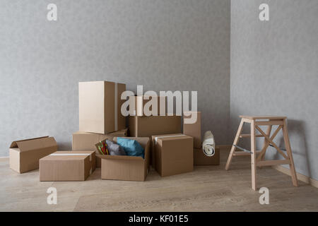 Kartons stapeln in neuen leeren Raum mit Leiter Stockfoto