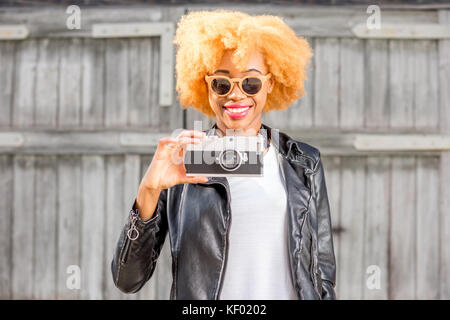 Lifestyle portrait einer afrikanischen Frau auf der hölzernen Hintergrund Stockfoto