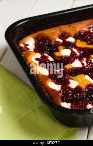 Frisch gebackene Kuchen mit Hüttenkäse und Marmelade in schwarz Backblech Stockfoto