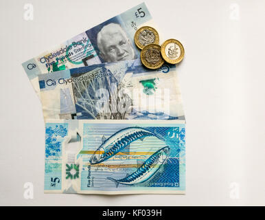 Sechseckige £ 1 Münzen und Polymer Schottischen £ 5 fünf Pfund Banknoten, Clydesdale Bank und Royal Bank of Scotland, mit zwei Makrelen durch Künstler Stuart Kerr Stockfoto
