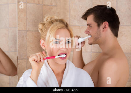 Portrait von Mann und Frau beim Zähneputzen im Bad zu Hause Stockfoto