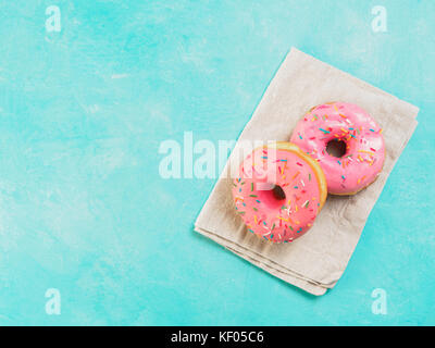 Rosa Donuts auf blauem Hintergrund, Kopieren, Ansicht von oben Stockfoto