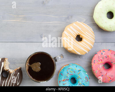 Donuts und Kaffee auf grauem Hintergrund Holz, Kopieren, Ansicht von oben Stockfoto