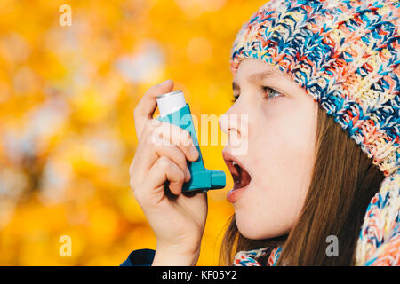 Junges Mädchen mit Asthma Inhalator in einem Park - chronische Krankheit, Allergie Remedy verursachtes Asthma und Allergie Krankheit Konzept Stockfoto