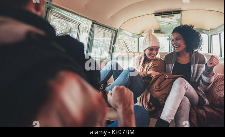 Weibliche Freunde reisen mit einem Van und genießen. Junge Frauen auf der Straße Reise Spaß in Van. Stockfoto