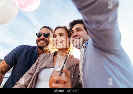 Junge Leute zusammen feiern und unter selfie. Gruppe Männer und eine Frau auf dem Dach party selfie. Stockfoto