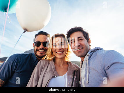 Junge Leute, die self portrait während einer Partei. Glückliche junge Männer und Frauen, die Self Portrait auf der Dachterrasse. Stockfoto