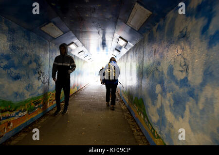 Surreale Ansicht von Fußgängern verschwommene Bewegung im Lackierten graffiti Unterführung Stockfoto