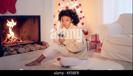 Frau in Leggings und Pullover sitzt weiß Baum Stockfoto