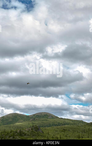 Große bewölkt Natur Landschaft mit Sonne hinter Wolken und kleinen gelben Flugzeug im Hintergrund fliegen ausgeblendet Stockfoto
