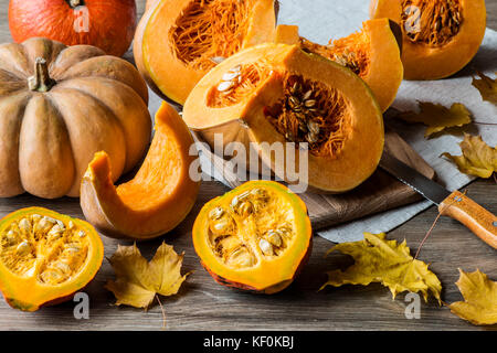 Kürbis in Scheiben geschnitten mit Samen auf einer hölzernen Hintergrund. close-up Stockfoto