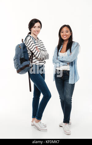 Paar zwei Multiethnischen Studentinnen mit Rucksack stehen und an der Kamera auf weißem Hintergrund Stockfoto