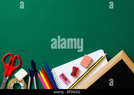Schulbedarf auf grünem Hintergrund. Zurück zum Konzept der Schule. Stockfoto