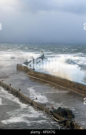 Burghead Hafen in Schottland durch die riesigen Wellen zerschlagen werden, stürzt über dem Meer Verteidigung auf während einem Sturm. Stockfoto