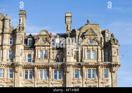 Edinburgh, Schottland, Vereinigtes Königreich. Handwerker Reparatur- und Reinigungsarbeiten Abseilstelle hinunter die Balmoral Hotel, früher der North British Hotel Stockfoto