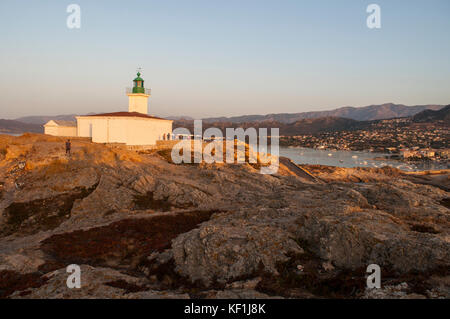 Korsika: Sonnenuntergang auf dem pietra Leuchtturm (1857) an der Spitze der Ile de la Pietra (Stone Island), den Felsvorsprung Île-Rousse (Rote Insel) Stockfoto