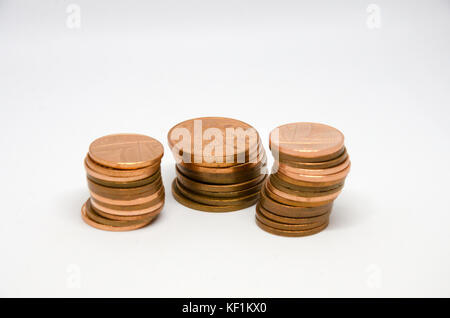 Stapel von paar Münzen auf einem weißen Hintergrund. Stockfoto