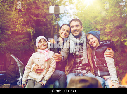 Familie mit Smartphone unter Selfie nahe am Lagerfeuer Stockfoto