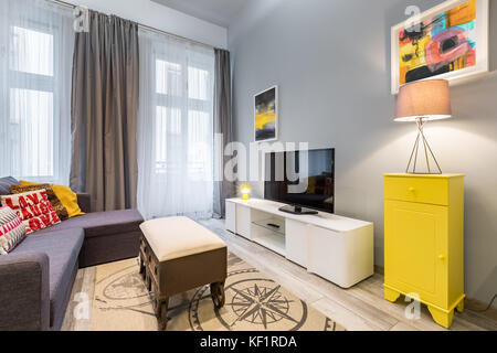 Modernes Wohnzimmer mit TV, Couchtisch und Gelben Kabinett Stockfoto
