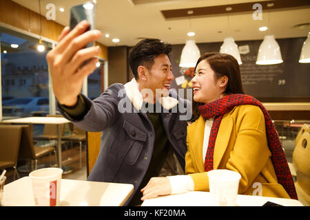Junge Liebhaber im Restaurant mit Handy Selbstauslöser Stockfoto