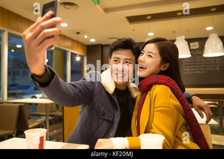 Junge Liebhaber machen Fotos im Restaurant Stockfoto